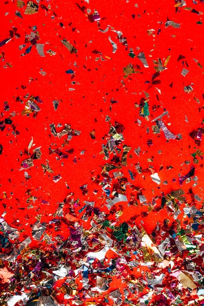 Colorful falling confetti on red background