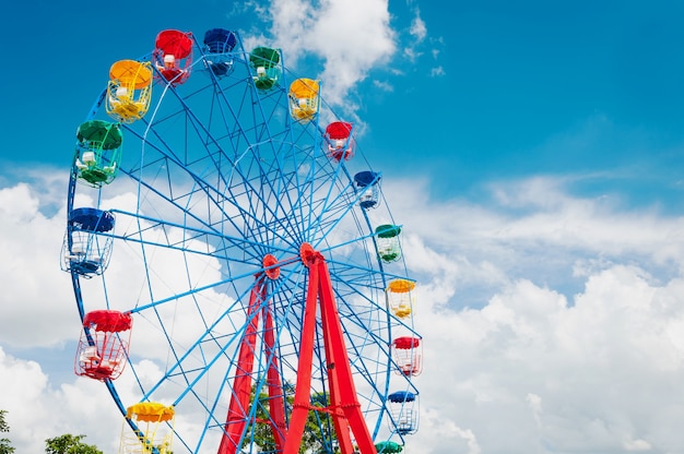 Цветное колесо обозрения с голубым небом, гигантский карусель с низким углом зрения на синем небе