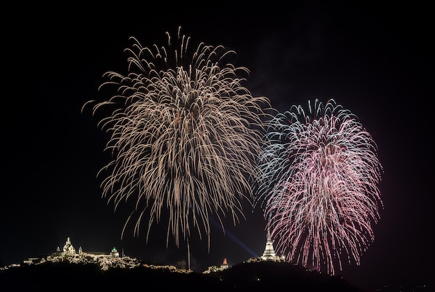 Colorful firework over  temple on hill, Thailand 