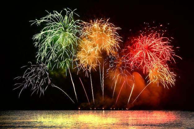 Celebrazione di fuochi d'artificio colorati dal mare con il cielo di mezzanotte