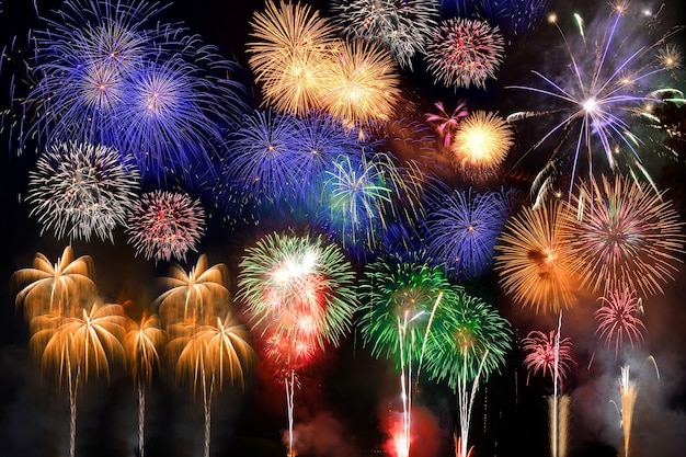 Colorful fireworks. Fireworks are a class of explosive pyrotechnic devices used for aesthetic and entertainment purposes. Visible noise due to low light, soft focus, shallow DOF, slight motion blur