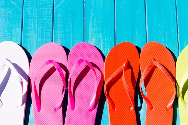 Colorful flip flops by a swimming pool.