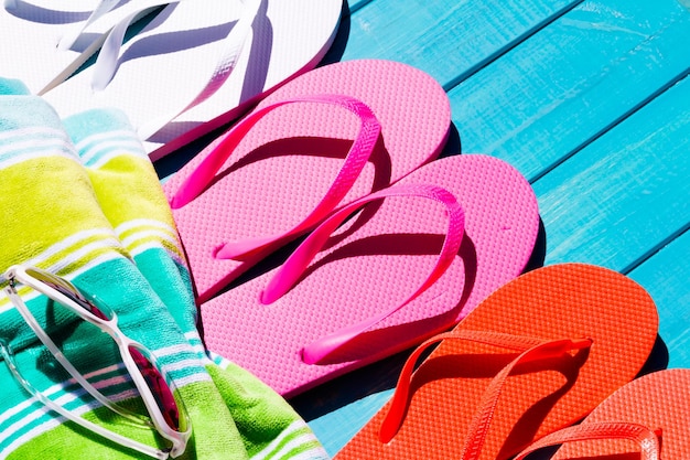 Photo colorful flip flops by a swimming pool.