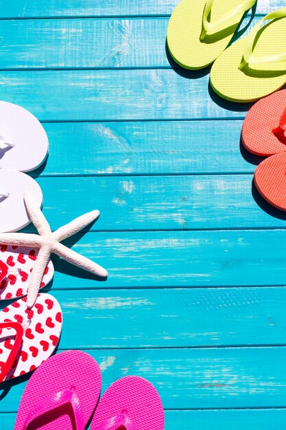 Colorful flip flops by a swimming pool.