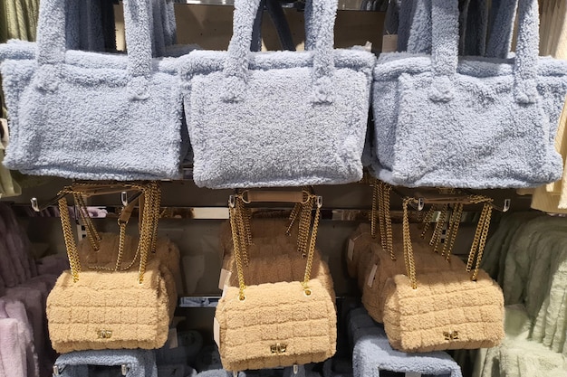 Colorful fluffy plush fabric bags hang on rack in clothing store