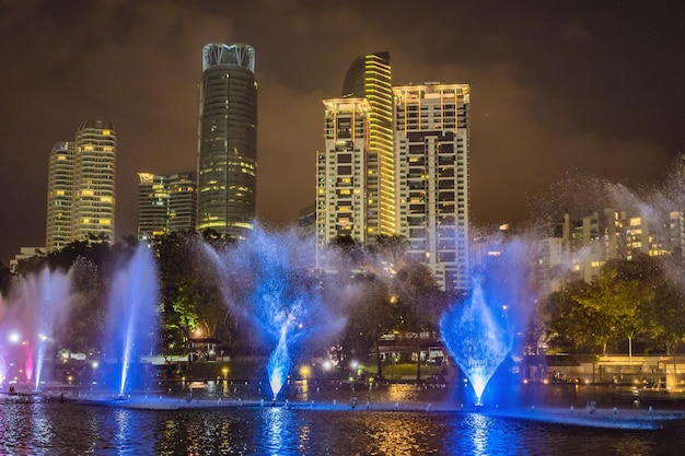 The colorful fountain on the lake at night near by Twin Towers with city on background Kuala Lumpur Malaysia