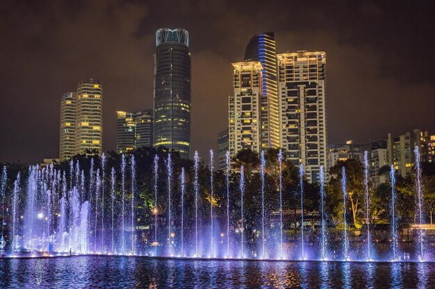 The colorful fountain on the lake at night near by Twin Towers with city on background Kuala Lumpur Malaysia