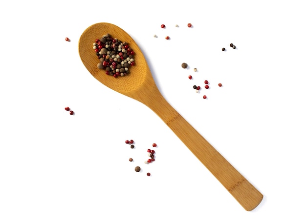 Colorful and fragrant black red pepper and allspice on a bamboo spoon Isolated on white background