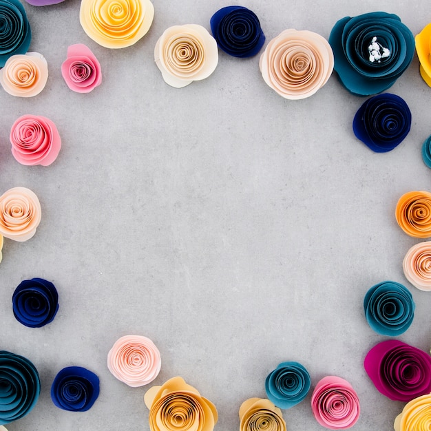 Colorful frame with paper flowers on cement background