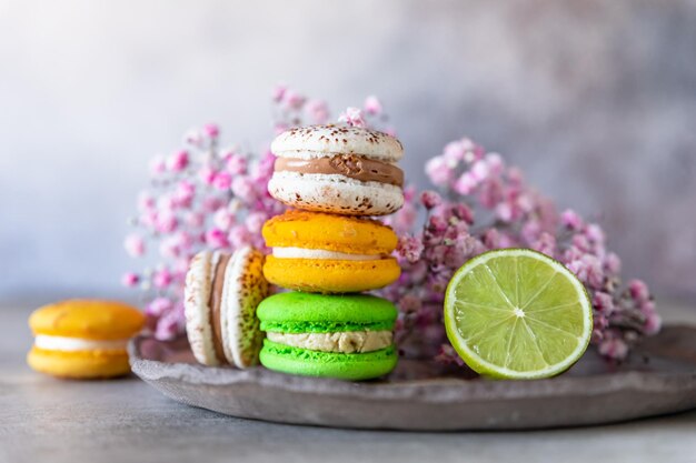 Foto macarons francesi o italiani colorati con lime e fiori sfondo dolce alimentare