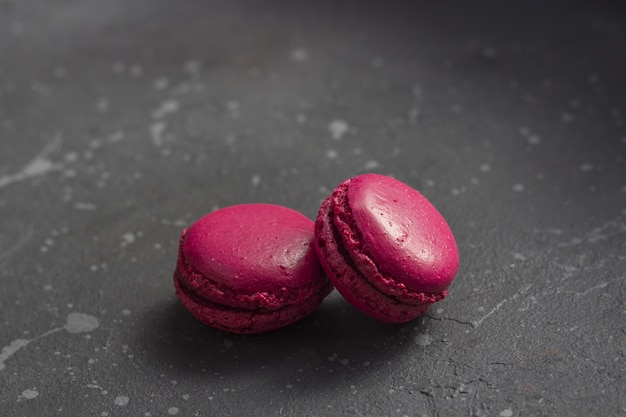 Colorful french macarons cookies (macaroons) on a dark background with copy space. /// TAGS MUST BE IN ENGLISH ////