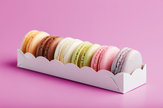 Colorful French macarons cookies in a package on a pink surface. Close-up, free space