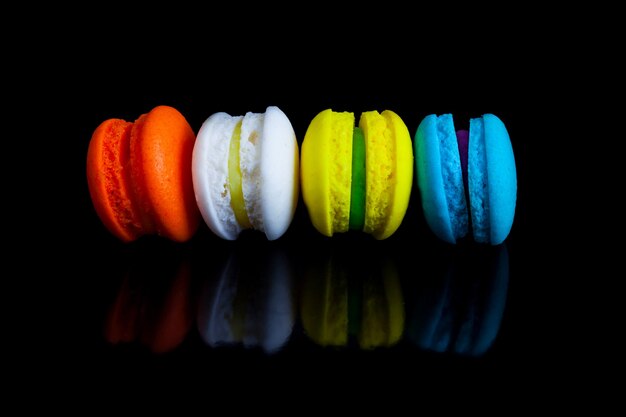 Colorful french macaroons on a black background.