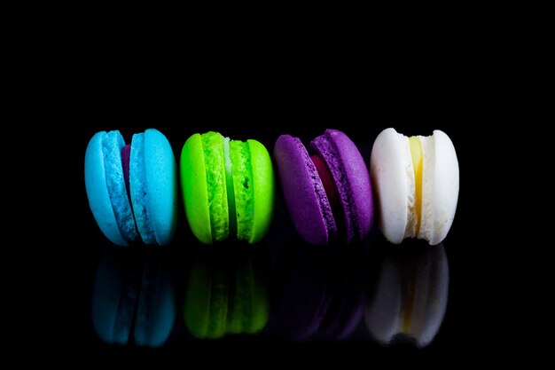 Colorful french macaroons on a black background.