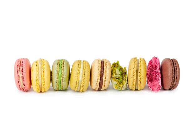 Colorful french macaroons in row isolated on white background