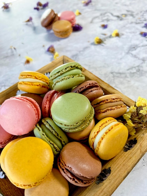 Colorful french macaroons on white marble background seen from above