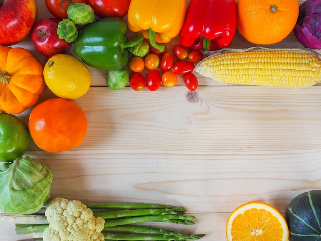 Frutta e verdure fresche variopinte su fondo di legno