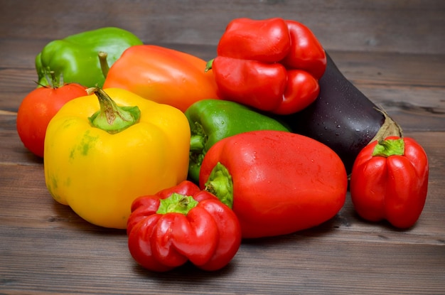 colorful fresh vegetables on wooden background bell peppers and eggplant and tomato close up