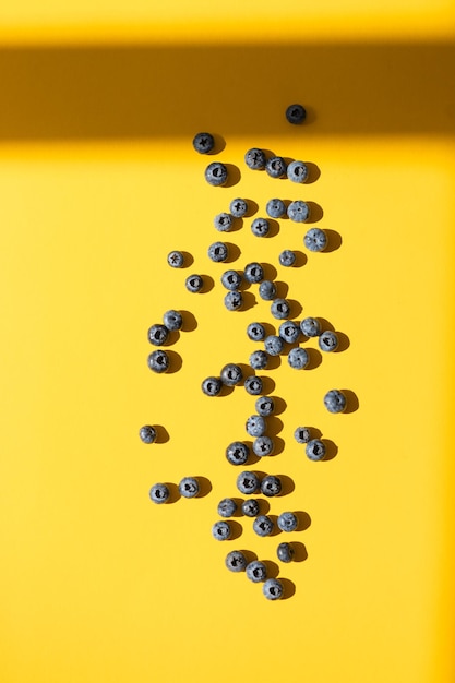 Colorful fruit pattern of blueberries on yellow background