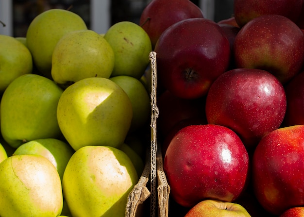 Colorful fruits on farmer's market Juicy red green apples in cartons