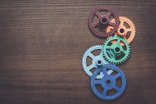 Colorful gears on the wooden background