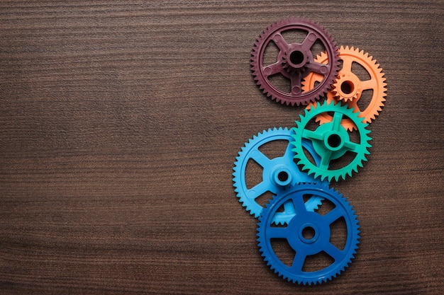 Photo colorful gears on the wooden background