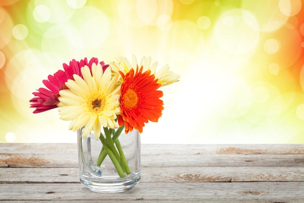 Colorful gerbera flowers on wooden table