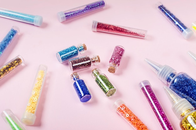 Colorful Glitter Bottles on a pink Background