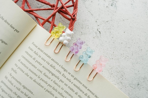 Foto orsi di gomma colorati graffette su una pagina di un libro attrezzature per la cancelleria