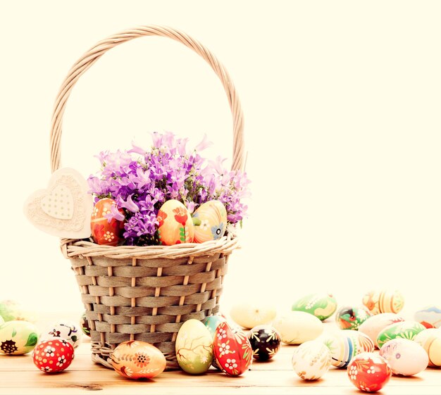 Photo colorful hand painted easter eggs in basket and on wood traditional decoration unique handmade design vintage