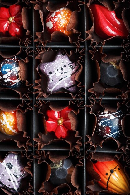 Colorful handmade chocolates in a box on a dark background