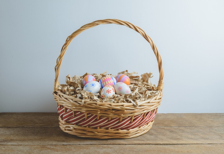 Photo colorful handmade easter eggs on straw paper in basket
