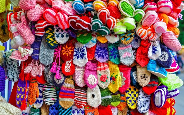 Colorful handmade socks and mittens on stalls of Christmas market in Riga of Latvia winter. Street Xmas and holiday fair in European city or town. Advent Decoration with Crafts Items on Bazaar