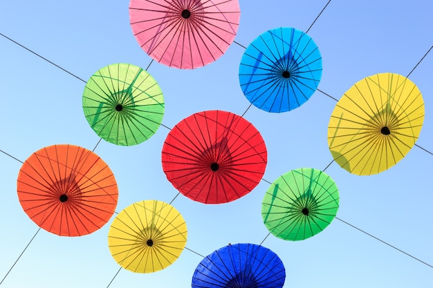 写真 カラフルな手作りの傘、電気ケーブルと空の背景にハングアップ