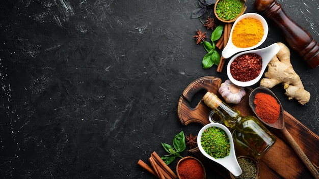 Colorful herbs and spices for cooking Indian spices On a black stone background Top view