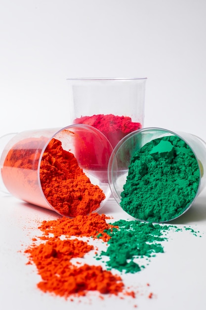 Colorful holi powder in a glass container isolated on white background