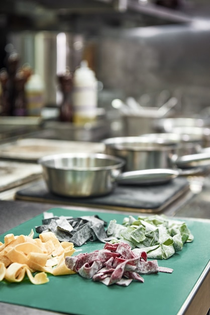 Foto pasta fatta in casa colorata stesa sul tagliere in cucina e pronta per essere cucinata