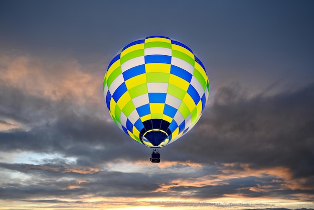 Colorful hot air balloon flying at sunset