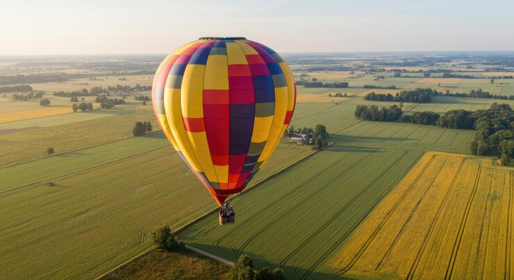 फोटो colorful hot air balloon flying over vast green fields