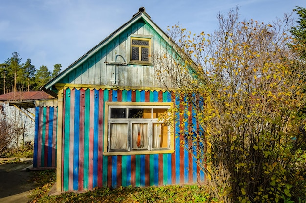 A colorful house in the countryside with a tree in the foreground