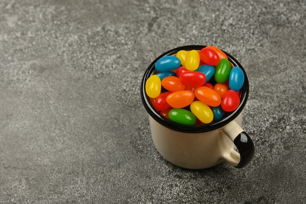 Colorful jelly beans in a mug on the table