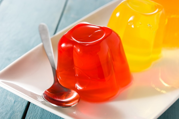 Colorful jelly on a plate on blue wooden background