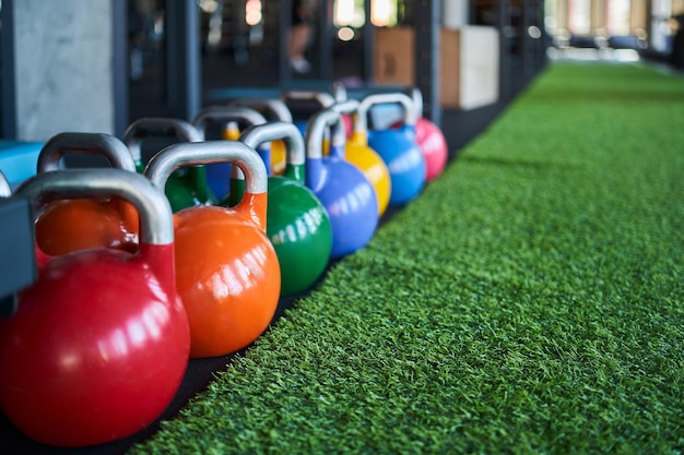 Colorful kettle bells in row on floor