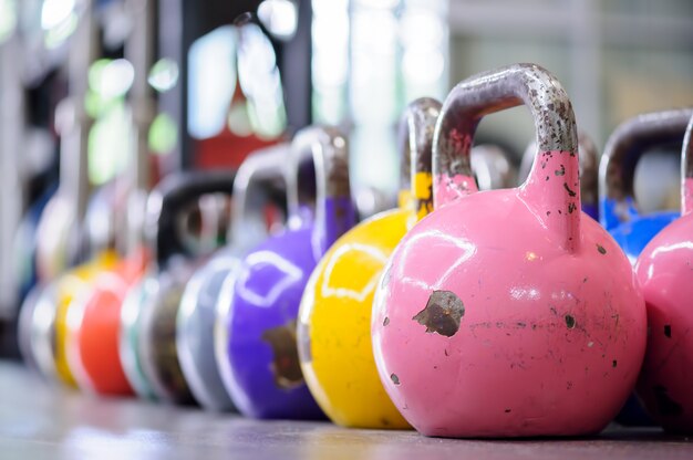 Colorful kettlebells in a row in a gym