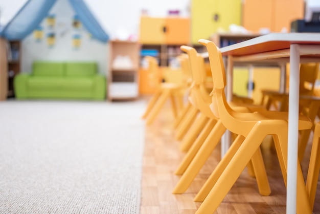 写真 チャイルズ学校教育机椅子おもちゃと背景の壁の装飾のないカラフルな幼稚園のクラス
