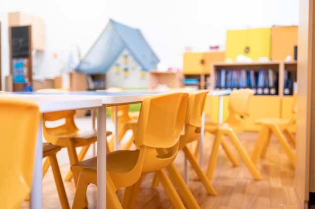 Foto classe di scuola materna colorata senza sedia da scrivania per l'educazione scolastica dei bambini giocattolo e decorazione sulla parete di fondo infanzia