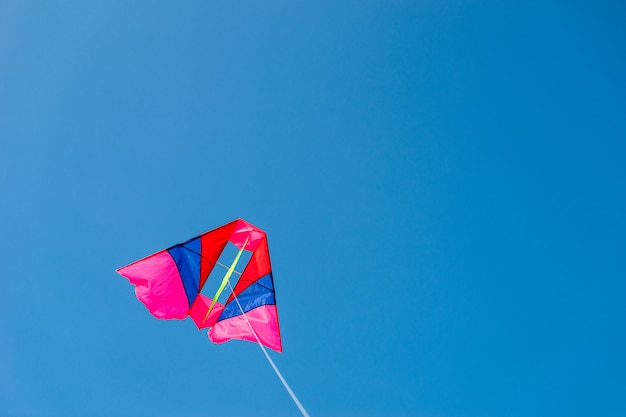 Photo colorful kite flying against blue sky background