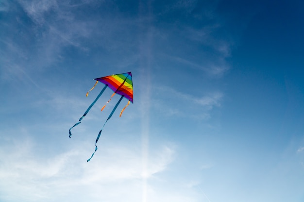 Colorful kite flying on the clear blue sky.