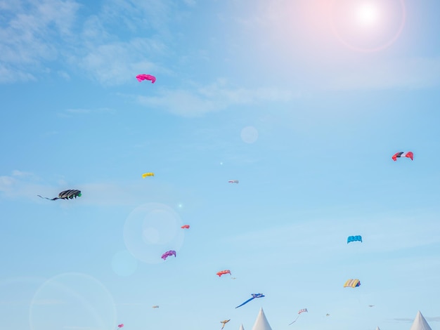 Colorful kites flying against the Windy weather is hobby in front of courtyard a blue sky at Kite Festival in satun thailand