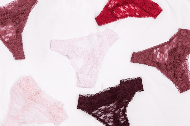 Красочные кружевные трусики на белой простыне Женский модный текстиль Женское белье Вид сверху